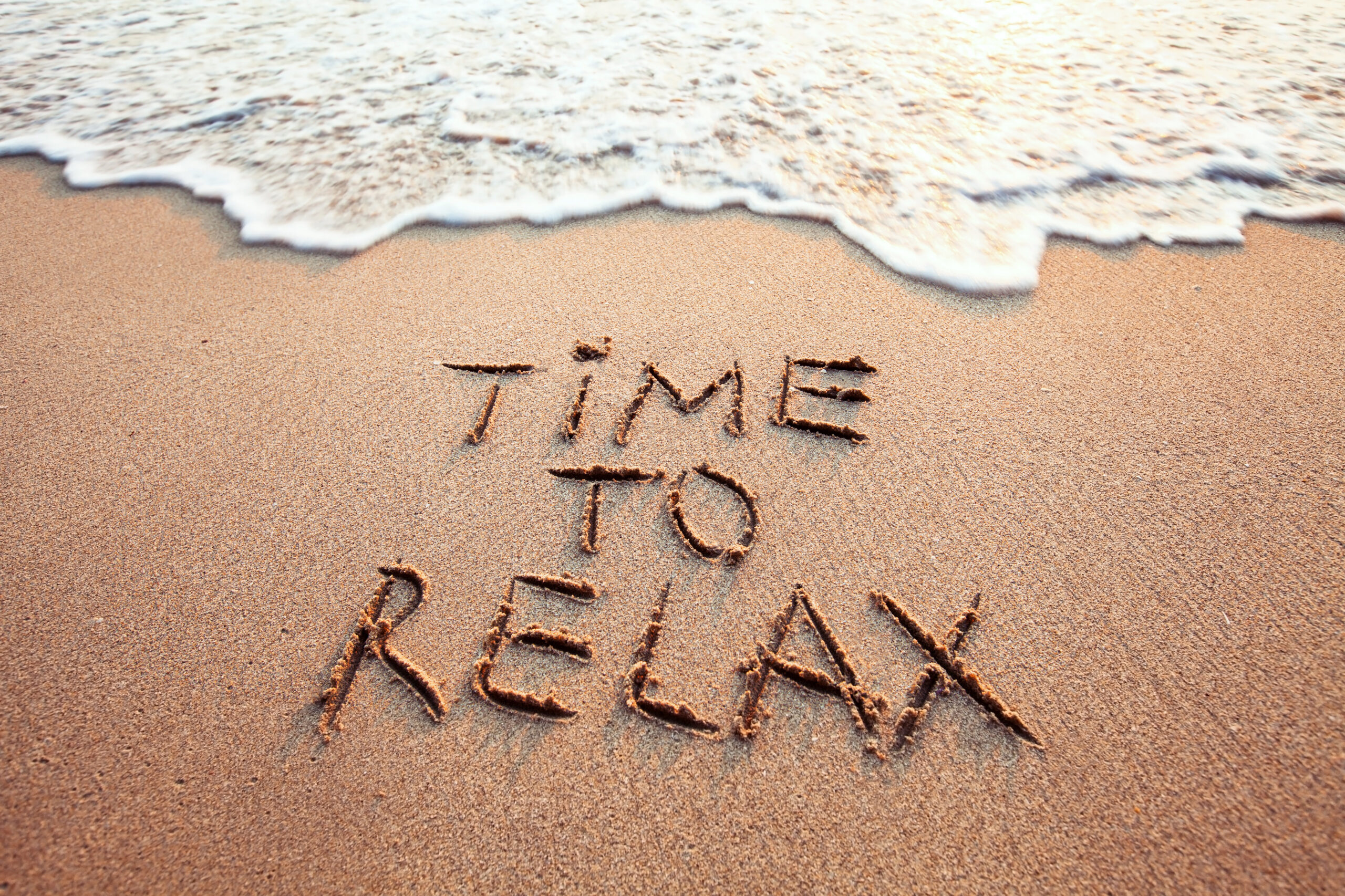 time to relax, concept written on sandy beach